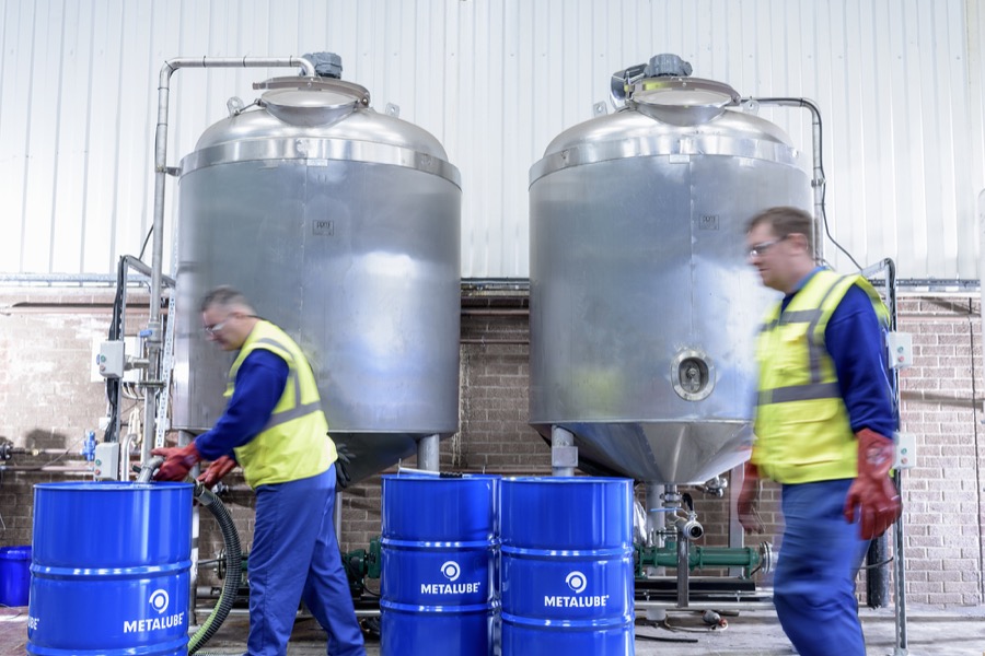 2 operatives filling Metalube industrial lubricant barrels